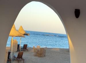 库塞尔Dolphin Continental Hotel的海滩上设有椅子和遮阳伞,还有大海
