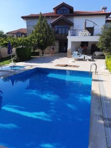 马纳夫加特4 yatak odalı Harika müstakil villa的一座大蓝色游泳池,位于房子前