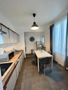 GagnySuper appartement chaleureux à 30min de Paris的一间带桌子的厨房和一间餐厅