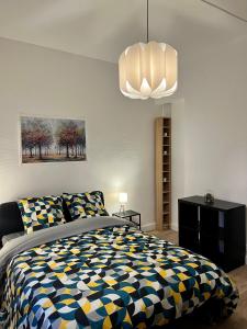GagnySuper appartement chaleureux à 30min de Paris的一间卧室配有一张床和一个吊灯