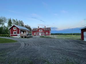 博伦厄Backes Lillstuga的一座红色的房子和一座带土路的谷仓