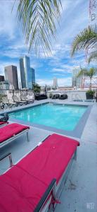 洛杉矶Huge Downtown LA Loft with Rooftop Pool & Jacuzzi的一个带椅子和红色毯子的游泳池