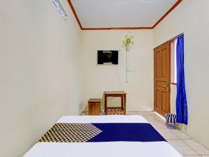 GlagahSPOT ON 92220 Sari Laut的一间卧室设有一张床、一台电视和一个窗口。