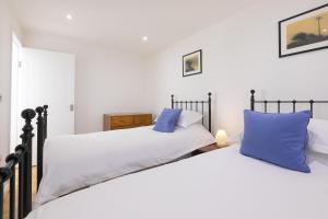 彭赞斯15 Boscaswell Downs的卧室内的两张床和蓝色枕头