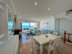 苏埃卡Breathtaking Beachfront House的用餐室以及带桌椅的起居室。