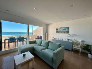 苏埃卡Breathtaking Beachfront House的带沙发的客厅,享有海景