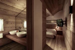 Madulain切萨司徒瓦科拉尼酒店的一间带两个盥洗盆的浴室和一张位于客房内的床。