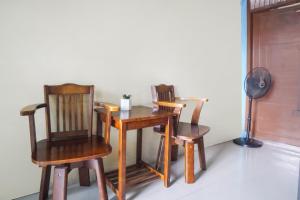 SunggalSUPER OYO 92075 Sky Residence Mawar的一张桌子、四把椅子和风扇