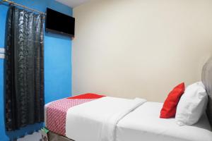 SunggalSUPER OYO 92075 Sky Residence Mawar的卧室配有白色的床和墙上的电视。