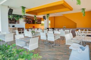 TubaráHotel Explore Caño Dulce的一间设有白色桌子和白色椅子的餐厅