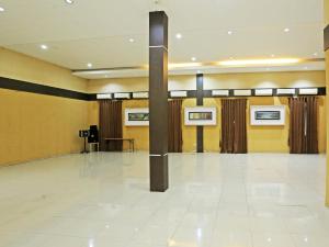 塞尔蓬Super OYO Townhouse OAK Hotel Fiducia Serpong的大房间设有黄色的墙壁和白色的瓷砖地板