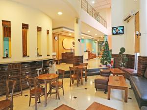 塞尔蓬Super OYO Townhouse OAK Hotel Fiducia Serpong的一间餐厅,配有桌椅和圣诞树