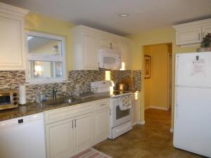 ChalfontRed brick house的厨房配有白色橱柜和白色冰箱。