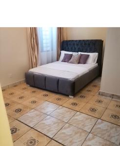 蒙巴萨Al Maaroof Appartment的卧室内的一张床位,铺有木地板