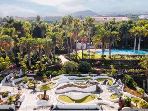 拉克鲁斯Precise Resort Tenerife的享有带游泳池和棕榈树的度假村的景致