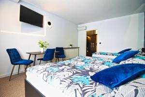 SkawaMotel Na Zbójeckiej的一间卧室配有一张带蓝色枕头的床和一张桌子