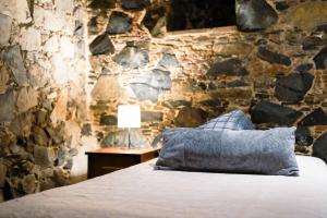尼科西亚Archontiko Rousias的一间卧室设有石墙、一张床和一盏灯
