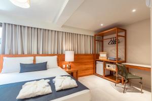嘎林海斯港MAIHAI Porto的一间卧室配有一张床、一张桌子和一把椅子