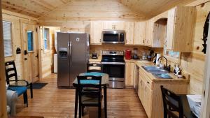 赛维尔维尔Smoky Hollow Outdoor Resort - Log Cabin的厨房配有不锈钢冰箱和木制橱柜
