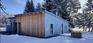 施托尔彭Ferienhaus im Wesenitztal的雪地中木板外墙的小房子