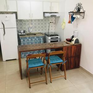 伦索伊斯Apartamento em Lencois - Bahia No 106的厨房配有两把椅子、一个柜台和冰箱