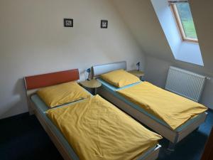 温佩尔克Apartment Hanny的小房间设有两张带黄床单的床