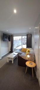 HillsboroughSpacious 2 Bed, Free Parking, Free Wifi - Serene Homes Sheffield的一间卧室配有一张床、一张桌子和一台电视。