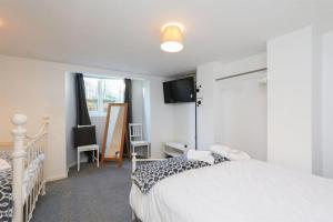 HillsboroughSpacious 2 Bed, Free Parking, Free Wifi - Serene Homes Sheffield的卧室配有白色的床和电视。