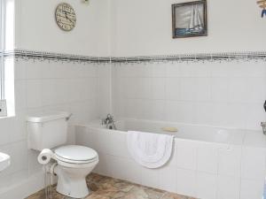 WhitsomeThe End Hoose的白色的浴室设有卫生间和浴缸。