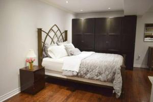 多伦多Home Away From Home - Basement Studio Apartment的一间卧室配有一张大床和木制床头板