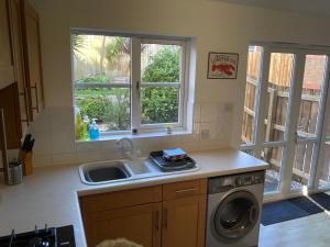 纽基Newly Renovated 2 Bed house nr Fistral Beach & Gannel Estuary的厨房配有水槽和洗衣机