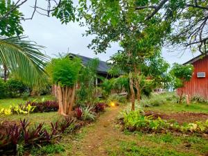锡基霍尔Winyanz Tambayan Tourist Inn的红谷仓前的花园
