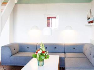 古兹耶姆5 person holiday home on a holiday park in Gudhjem的客厅配有蓝色的沙发和带鲜花的桌子