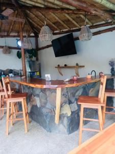 蒙塔尼塔Tres Palmas的一间石头酒吧,位于带椅子和电视的房间