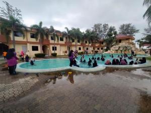 瓜拉丁加奴Seri Indah Resort的一群人坐在游泳池周围
