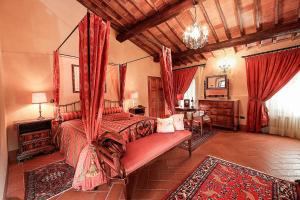 基安蒂盖奥勒Castello Di Tornano Wine Relais的一间卧室配有一张天蓬床和一张桌子