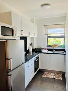 帕皮提Tehautahi Cozy Lodge的厨房配有冰箱和微波炉。