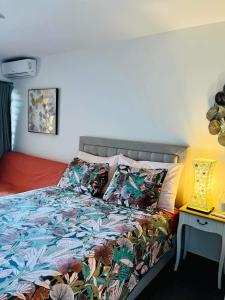 帕皮提Tehautahi Cozy Lodge的一间卧室配有一张带五颜六色棉被的床