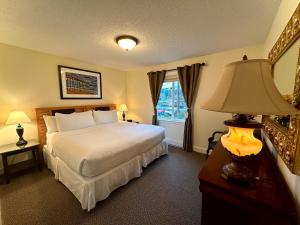 尤克卢利特湾岸海滨旅馆的一间卧室配有床、灯和窗户