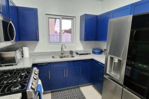 卢西Snooze at Oceanpointe的厨房配有蓝色橱柜、水槽和冰箱。