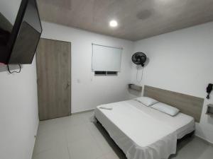 SoledadHOTEL MAR DEL CARIBE的一间卧室配有一张床和一台平面电视