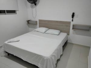 SoledadHOTEL MAR DEL CARIBE的白色客房的白色床,铺有白色地板