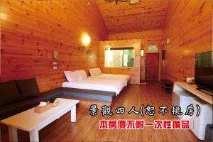 鹿谷乡听涛园山庄的一间卧室配有一张床、一张沙发和一台电视。