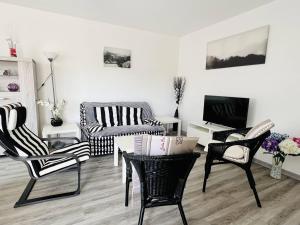 康博莱班Appartement Cambo-les-Bains, 2 pièces, 2 personnes - FR-1-495-14的客厅配有黑白椅子和桌子