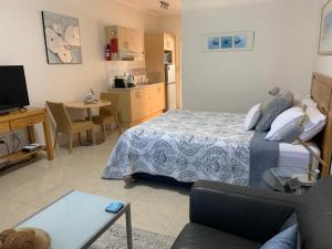 蚬壳港贝壳港鹈鹕休闲公寓的一间卧室设有一张床和一间客厅。