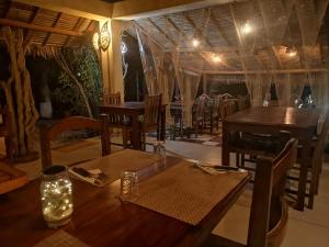 迭戈苏瓦雷斯Hotel Lakana Ramena的用餐室配有木桌和椅子及灯