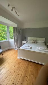 温德米尔Meadowside Troutbeck Bridge, Windermere sleeps 5-6的卧室配有白色的床,铺有木地板