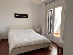 艾姆布里亚布拉瓦Maison 3 chambres proche plage amarre 7 m的白色的卧室设有床和窗户