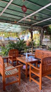 拜县topp stay hostel的一个带木桌和椅子的庭院和绿色屋顶