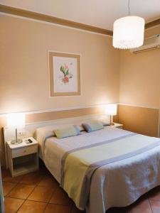 圣安蒂奥科意大利餐厅摩登酒店的一间卧室配有一张大床和两盏灯。